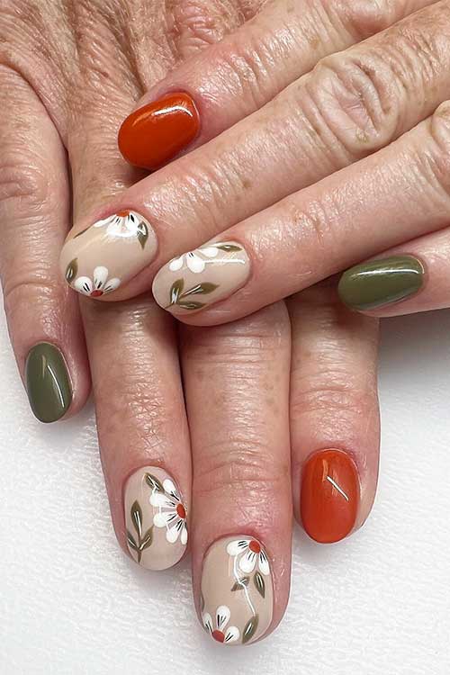 Burnt orange and olive green nails with leaf nail art and flowers on two accent beige nails.