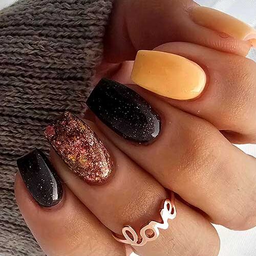 Coffin yellow and black short fall nails adorned with an accent autumn hue glitter nail and a touch of silver glitter