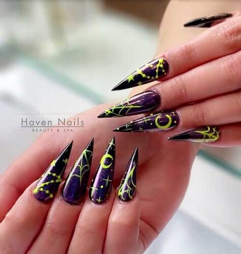 Dark purple Stiletto witchy nails with neon yellow celestial nail art and cobwebs