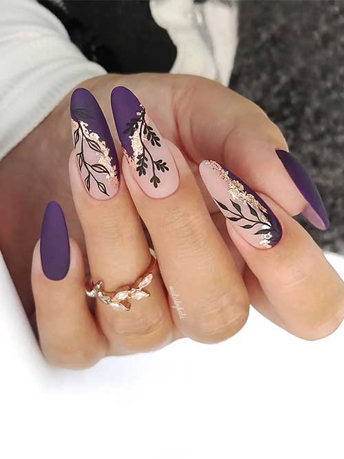 Long almond shaped matte purple fall nails with negative space adorned with black leaf nail art and gold foil flakes.