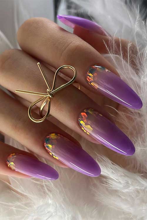 Long almond shaped ombre purple nails with encapsulated glitter in different colors.