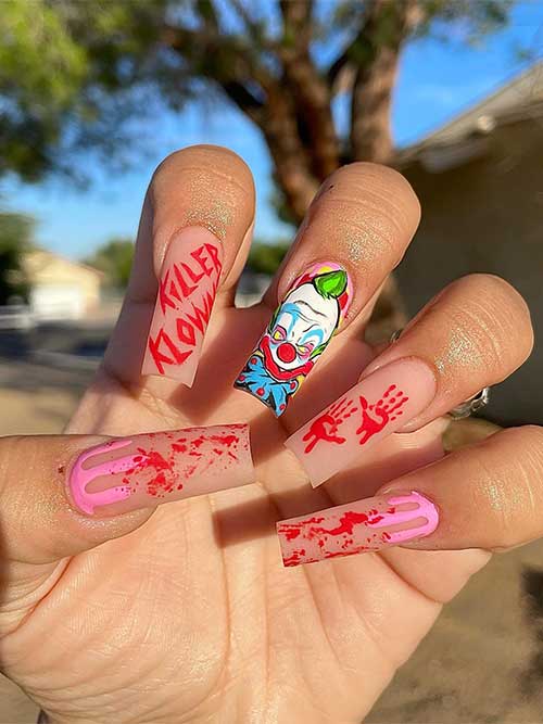 Nude Halloween nails with blood splatter, bloody hand print, pink drip nail art, and a scary killer clown on an accent nail