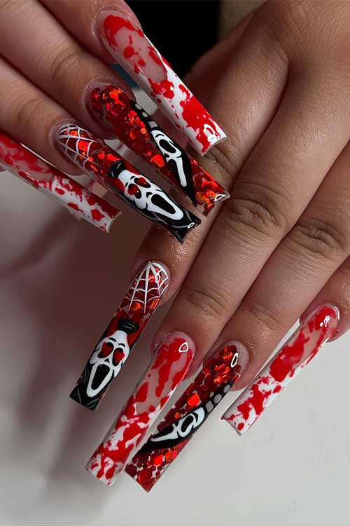 Scary blood splatter Halloween nails with scary faces, glitter, cobwebs, and two accent white French nails