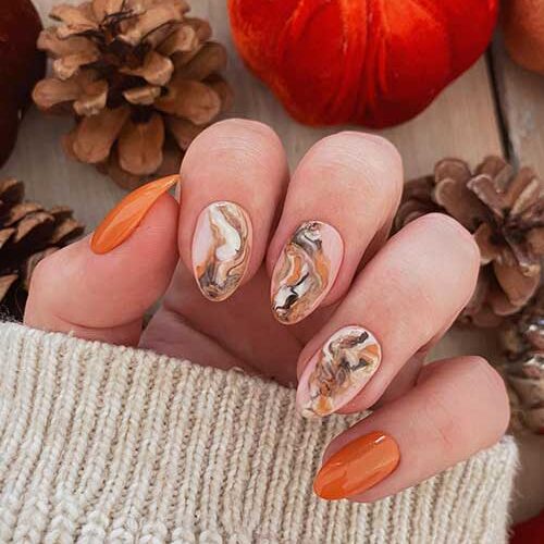 Short Burnt Orange Nails with Burnt Orange, White, and Black Marble Nail Art on Nude Pink Accent Nails