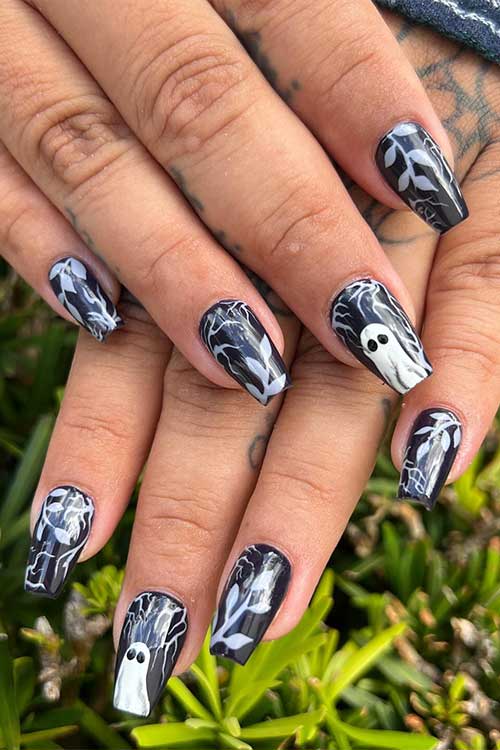 Short black coffin nails with white ghosts and leaf nail art for Halloween 2023