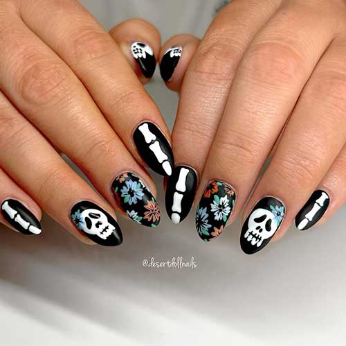 Short black nails with bones, skulls, and cemetery flowers