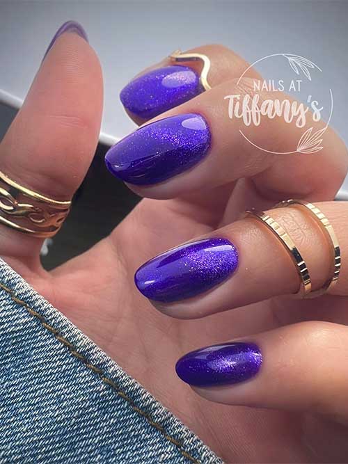 Short cat eye nails purple with some glitter.