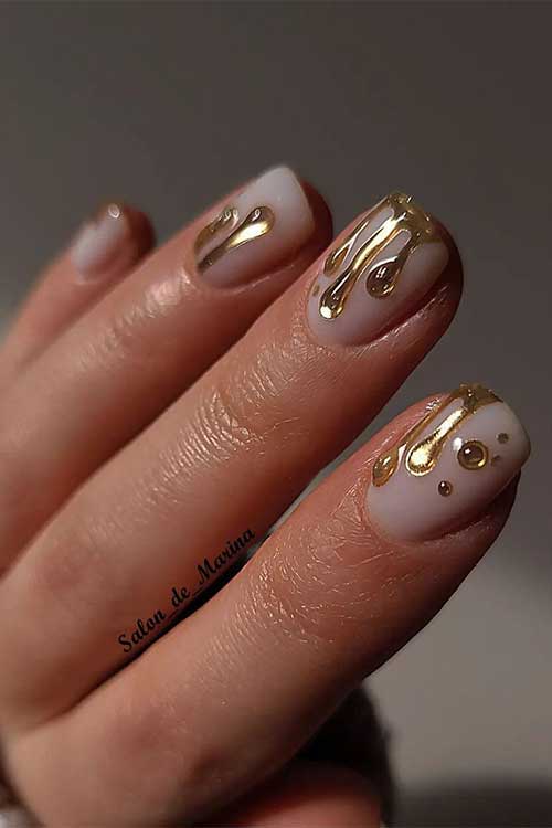 Short gold chrome drip nails on nude base color. Short gold chrome drip nails on nude base color.