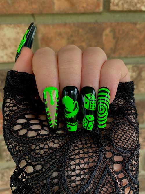 Long glossy coffin black nails feature an Oogie nail art, a stitch, a swirl, and a cobweb nail art. 