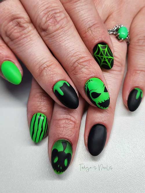 Short round-shaped matte black and green nails feature Oogie nail art, pumpkin, cobweb, and drip nail art Short round-shaped matte black and green nails feature Oogie nail art, pumpkin, cobweb, and drip nail art