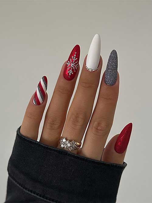 Long almond-shaped red Christmas nail design features a silver rhinestones snowflake, a candy cane nail, and a white accent