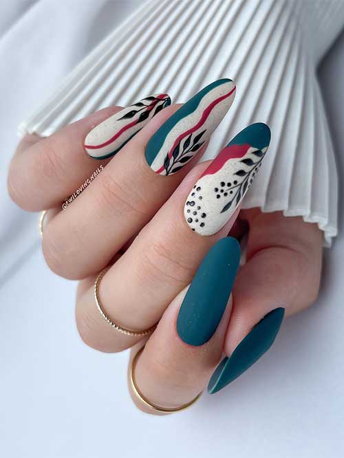 Long matte loyal blue nails with three accent off-white nails adorned with abstract nail art and black leaf nail art design Long matte loyal blue nails with three accent off-white nails adorned with abstract nail art and black leaf nail art design