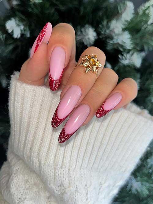 Long almond shaped dark red French manicure with a touch of gold glitter over a nude pink base color.