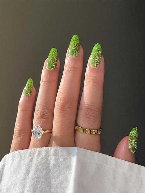 Reflective almond-shaped glitter green New Year’s nails for a magical look