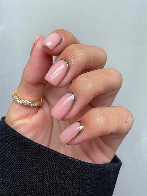 Simple and festive gold chrome reverse French New Year’s nails over a nude pink base color