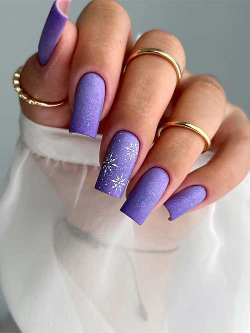 Stunning matte winter purple nails square shaped long adorned with a touch of glitter and white snowflakes on an accent nail