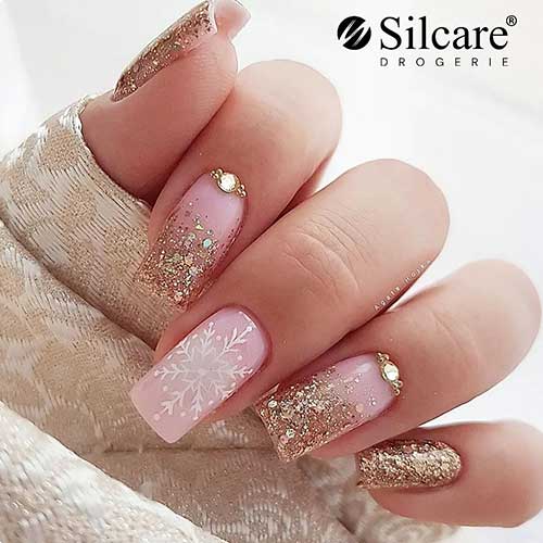 These gold glitter nails with an accent nude pink nail adorned with a big snowflake are one of the best winter nail designs