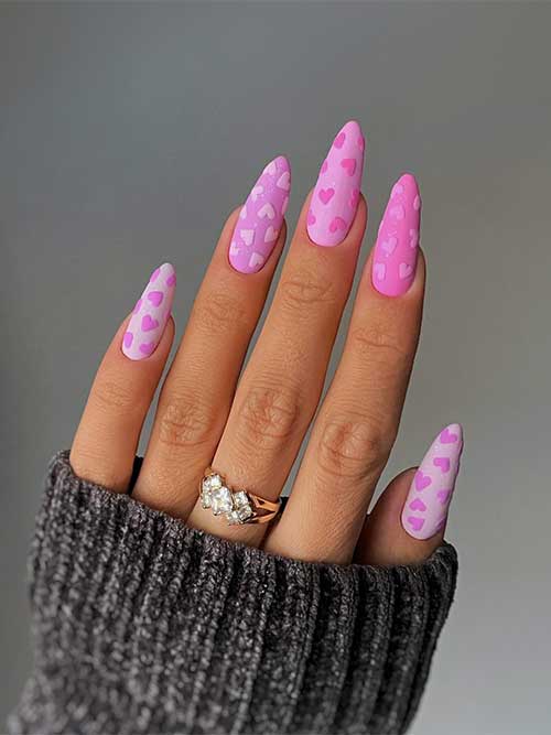 Cute long almond-shaped matte different shades of pink nails with small heart shapes over all nails