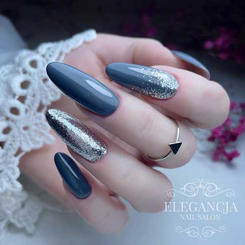 Glossy long almond dark gray nails with a silver foil nail and another gray nail adorned with a touch of silver foil