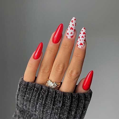 Long almond-shaped red and white Valentine’s Day nails with tiny red hearts are one of the best Valentine's Day nail designs