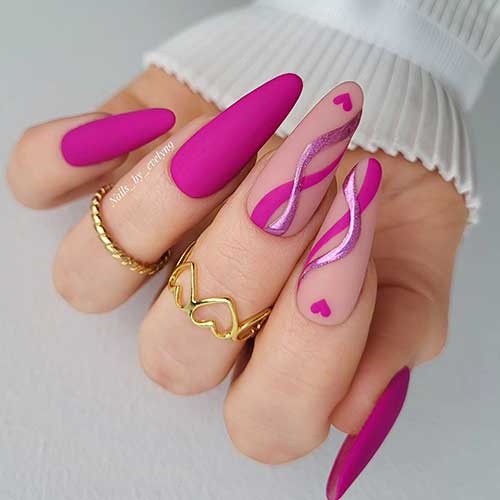 Matte magenta pink Valentine's Day nails long almond-shaped with two accent nude nails adorned with a heart shape and swirls Matte magenta pink Valentine's Day nails long almond-shaped with two accent nude nails adorned with a heart shape and swirls