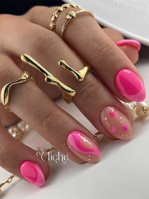 Short hot pink Valentine's Day nails with light French tips and two nude accent nails adorned with white dots and pink hearts