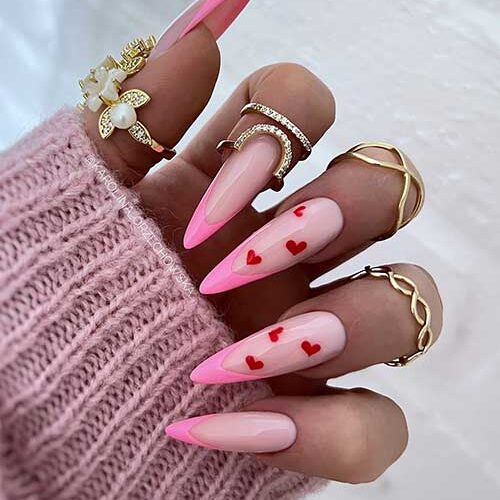 Stiletto classic French light pink Valentine's Day nails with small red hearts on two accent nails