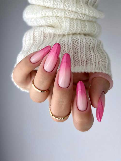 Stunning long almond-shaped light to hot pink ombre nails with glitter pink negative space French tips