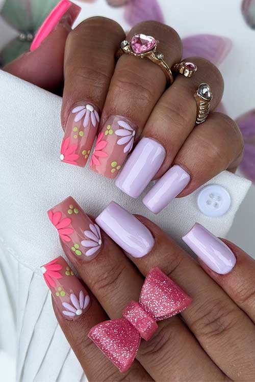 Light purple nails with a hot pink accent, nude nails featuring pink and purple flowers, and green dots for a spring vibe. Light purple nails with a hot pink accent, nude nails featuring pink and purple flowers, and green dots for a spring vibe.