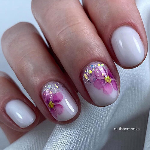 Short gel milky white nails with pink flowers on two accent nails