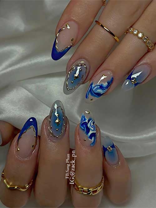 Elegant blue and gold nail art featuring intricate French tips, marbled patterns, and shimmering gold foil accents. Elegant blue and gold nail art featuring intricate French tips, marbled patterns, and shimmering gold foil accents.