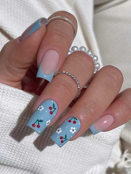 Light blue manicure featuring classic French tips and cherry floral accents, blending elegance with a whimsical touch. Light blue manicure featuring classic French tips and cherry floral accents, blending elegance with a whimsical touch.