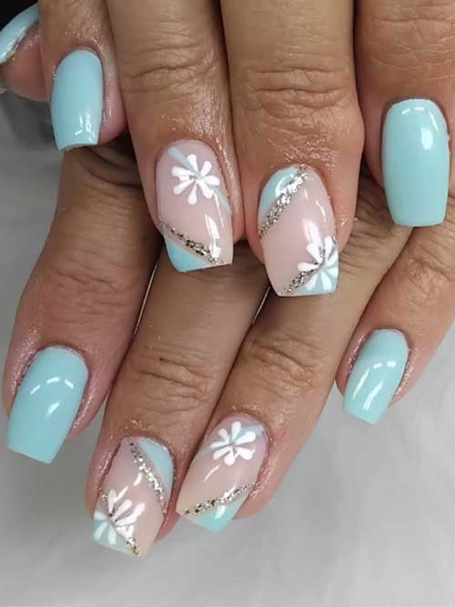 Light blue nails with nude accents, glittery stripes, and white flowers, exuding winter elegance and frosty sophistication. Light blue nails with nude accents, glittery stripes, and white flowers, exuding winter elegance and frosty sophistication.