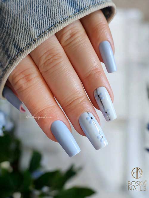 Soft blue nails adorned with intricate flowers and a silver stripe, embodying a serene and refined style. Soft blue nails adorned with intricate flowers and a silver stripe, embodying a serene and refined style.