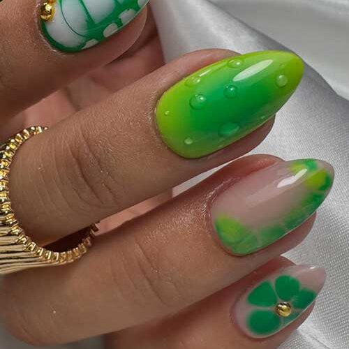 Jungle-cute green nails featuring neon and emerald gradients, marbled textures, reptilian accents, and gold stud embellishments.
