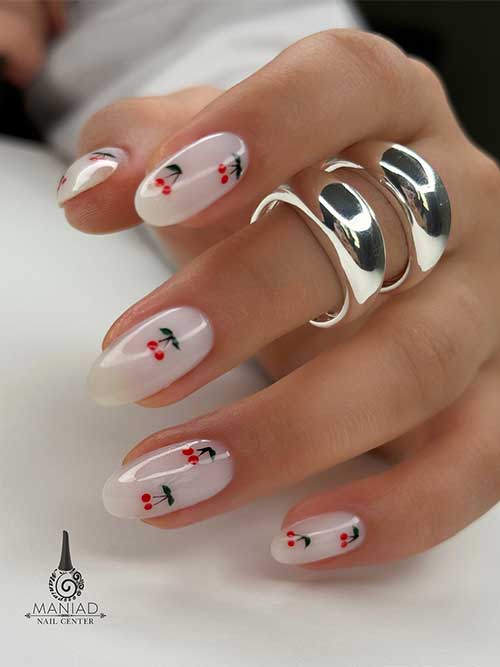White nails with tiny red cherries and green leaves on a sheer base, adding a playful, summery touch to your look. White nails with tiny red cherries and green leaves on a sheer base, adding a playful, summery touch to your look.