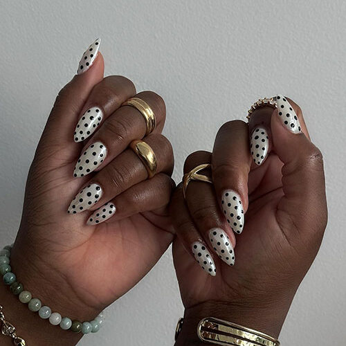 Cute polka dot summer nails with a white background and black dots, offering a chic look for any sunny occasion.