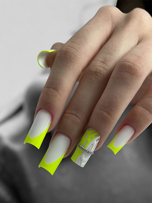 Matte neon yellow nails featuring neon yellow French tips and a unique swirling design on one accent nail, with a silver ring